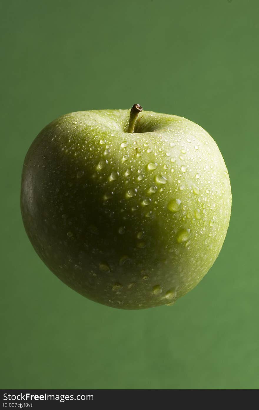 Isolated green apple appears to be floating on green background