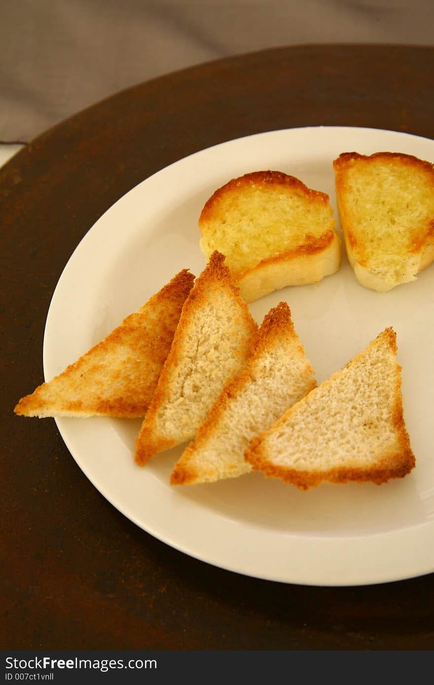 Pieces of white toasted bread on a white plate isolated