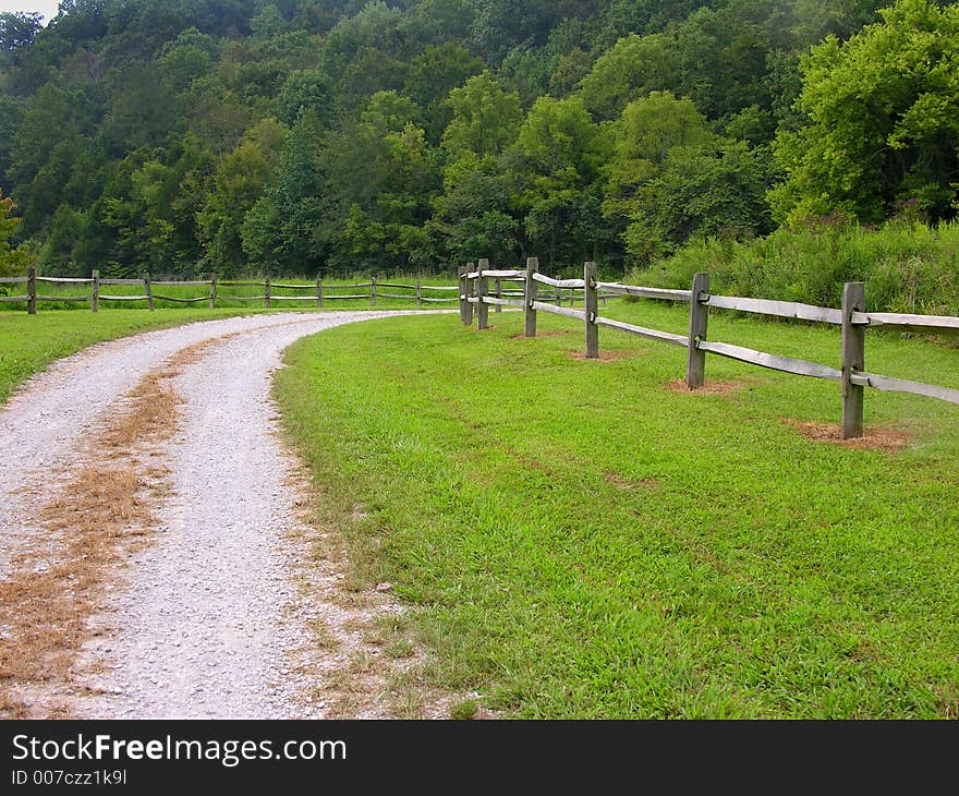 Gravel road with rail fence. Gravel road with rail fence.