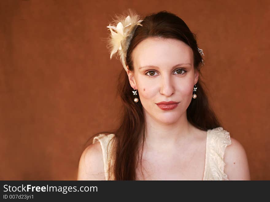 Portrait of a beautiful young woman with feathers in her hair. Portrait of a beautiful young woman with feathers in her hair.