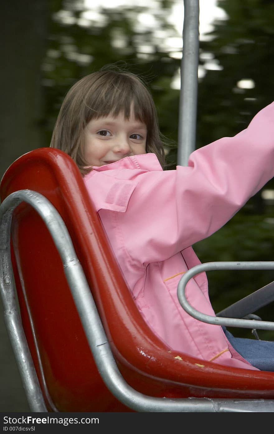 Young girl on the playground-lift in the red seat