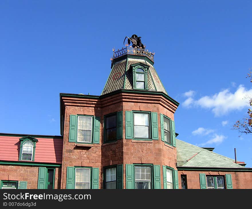 A Grim Reaper Standing On Top Of A Gothic House. A Grim Reaper Standing On Top Of A Gothic House