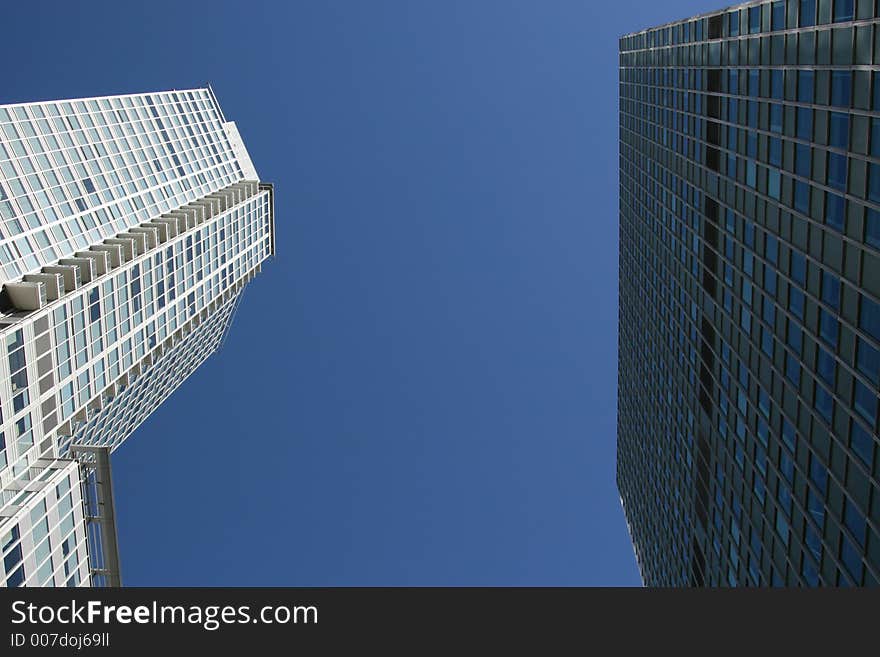 Double corporate downtown office buildings looking up toward the blue sky. Excellent for corporate brochure. Double corporate downtown office buildings looking up toward the blue sky. Excellent for corporate brochure.