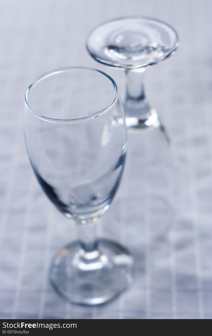 Two empty wine glasses on a white surface