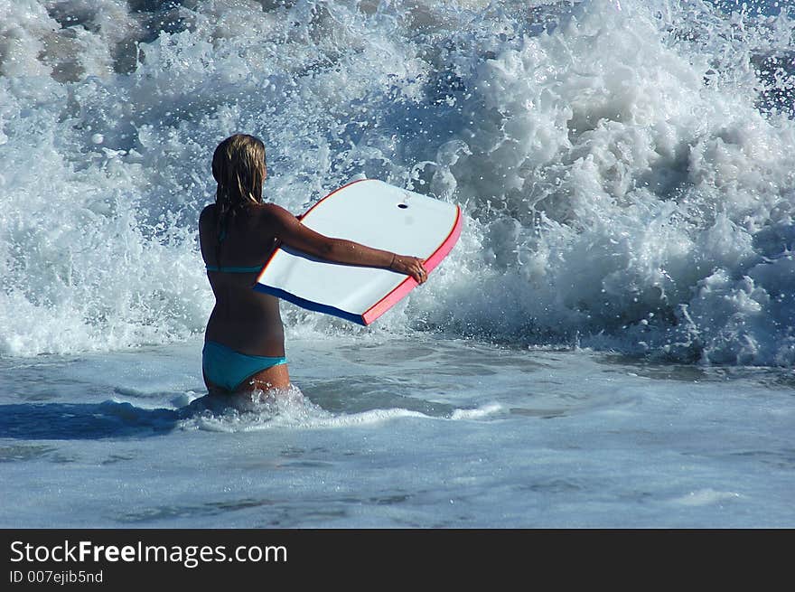 A girl with buddy board in the ocean. A girl with buddy board in the ocean