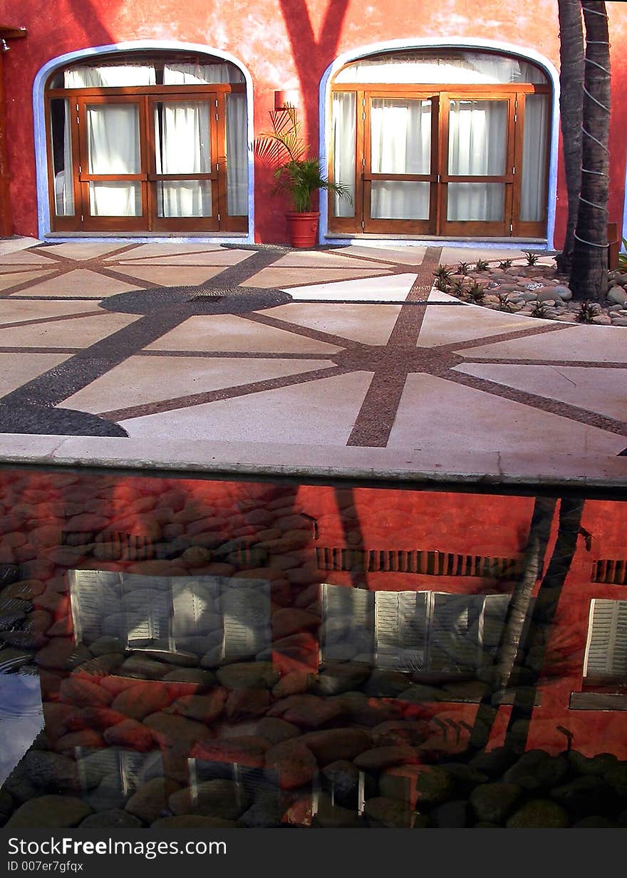 Building and trees reflected in a shallow stone-filled pool in Careyes, Mexico. Building and trees reflected in a shallow stone-filled pool in Careyes, Mexico