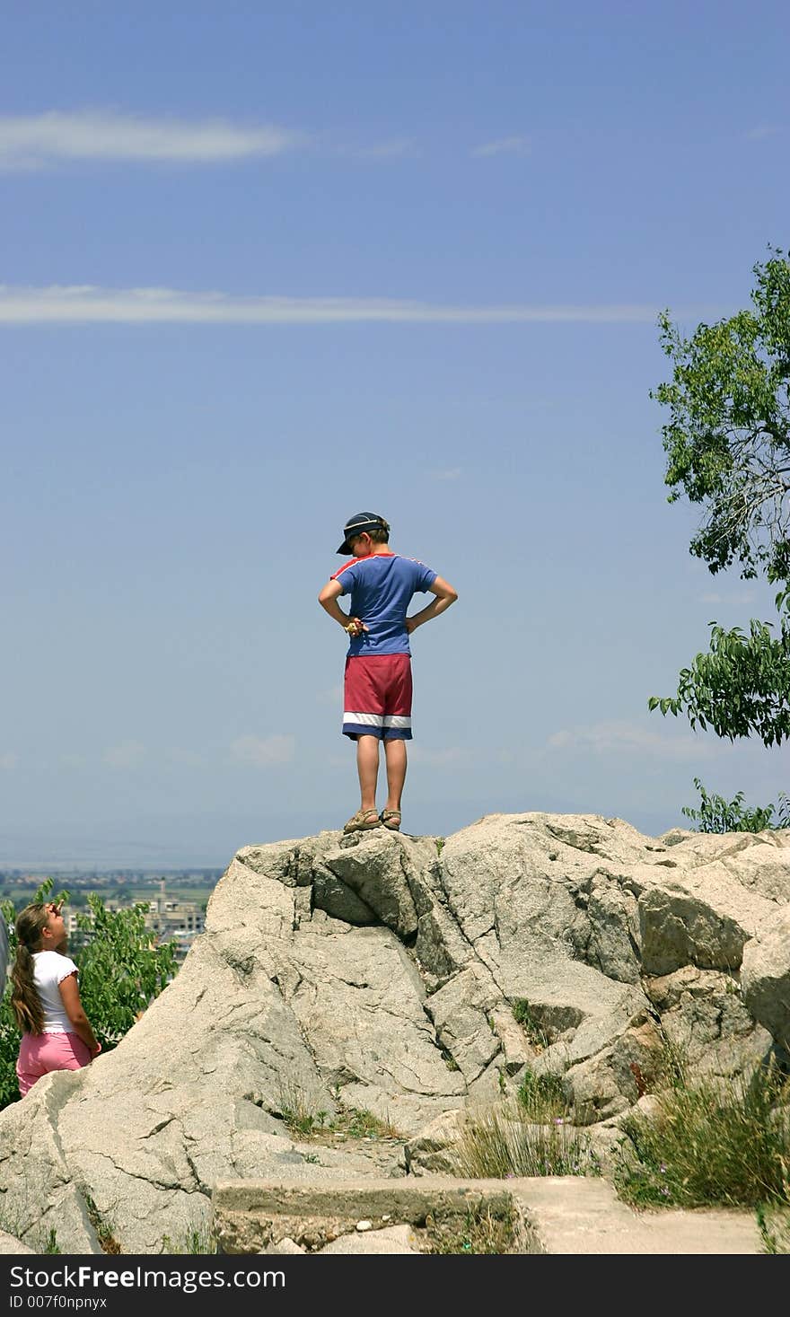 The teenager stands on a mountain, girl below
