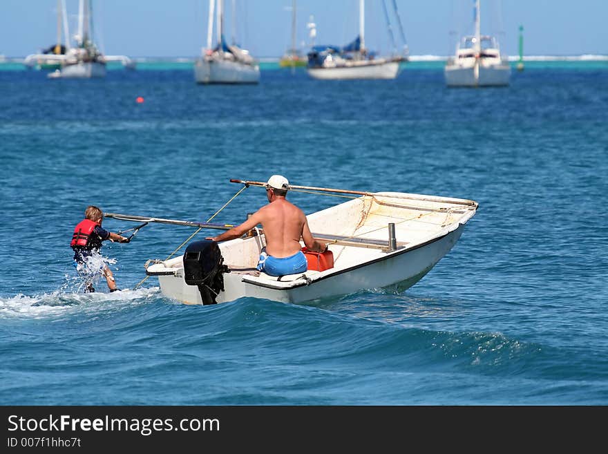 Boy learning waterski with instructor on a boat. Boy learning waterski with instructor on a boat