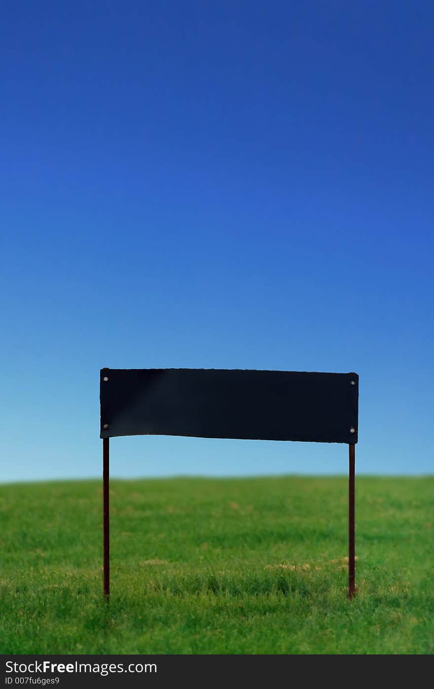 Blank sign on grass under perfect blue sky. Blank sign on grass under perfect blue sky