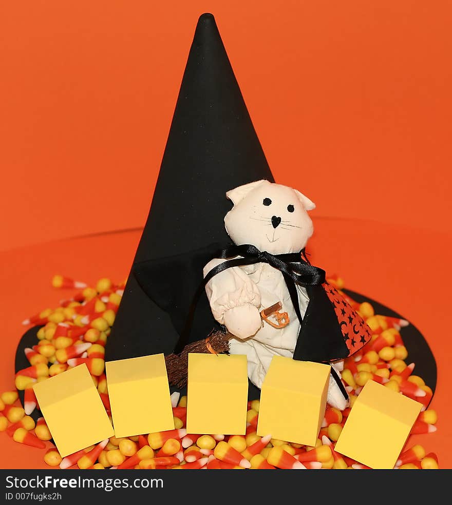 Halloween scene with a cat dressed as a witch, a big witch's hat, candy corn and blank foam blocks. Halloween scene with a cat dressed as a witch, a big witch's hat, candy corn and blank foam blocks