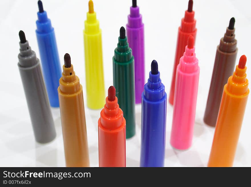 Close-up of colored markers standing with caps off