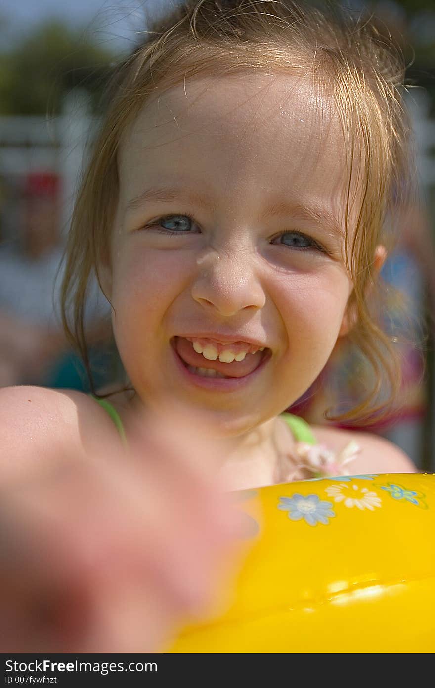 2 year old little girl laughing and reaching for the camera.