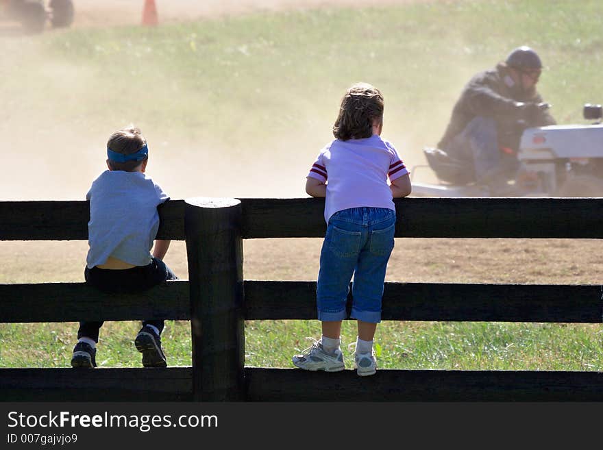 Boy and girl looking at small car race. Boy and girl looking at small car race