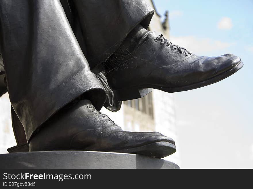 Feet of a statue with shoes on.