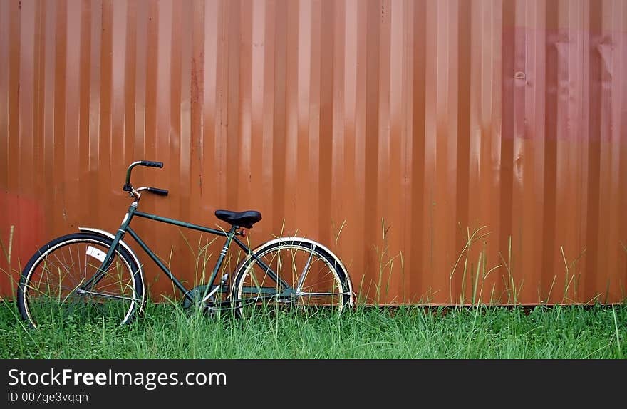 A bike leaning against a huge medal contanear