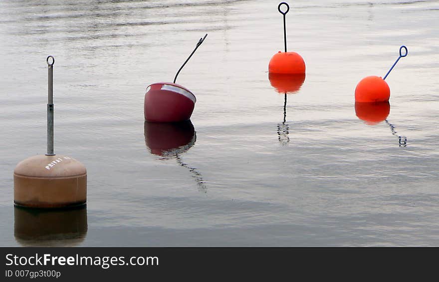 Four buoys reflecting in the water