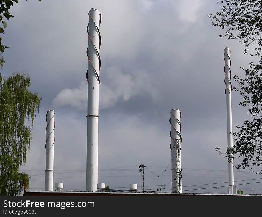 Industrial chimneys and factory fumes against a cloudy sky. Industrial chimneys and factory fumes against a cloudy sky