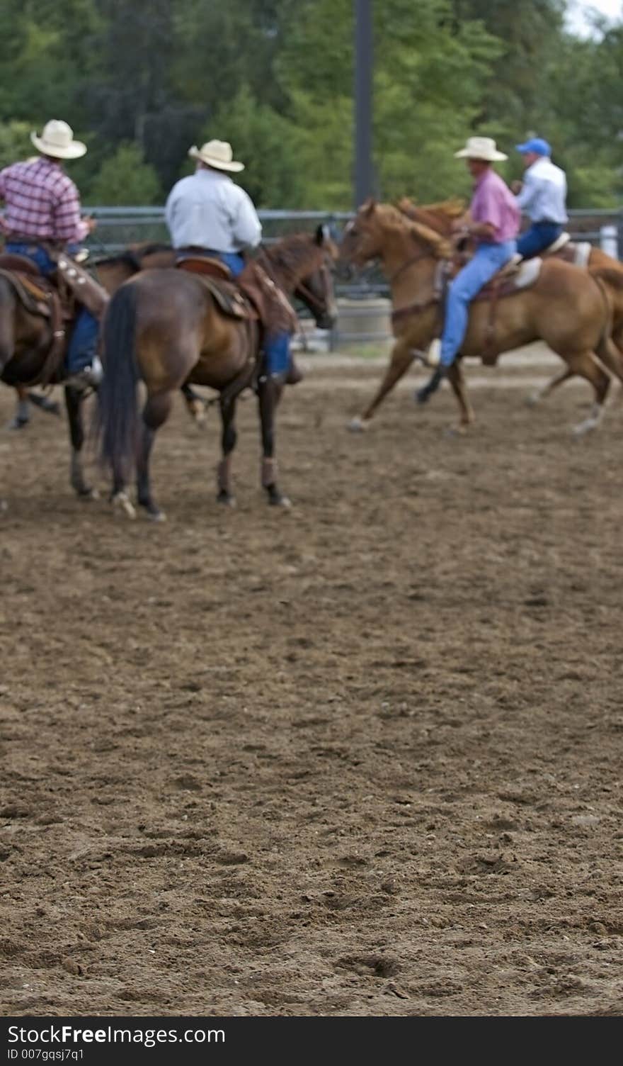 Out of focus cowboys at rodeo event - atmospheric effect with foreground in focus. Out of focus cowboys at rodeo event - atmospheric effect with foreground in focus