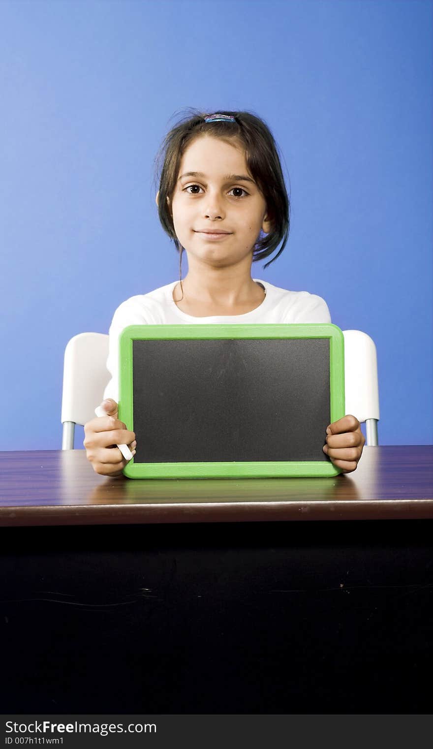 Little girl showing chalkboard in classroom. Little girl showing chalkboard in classroom