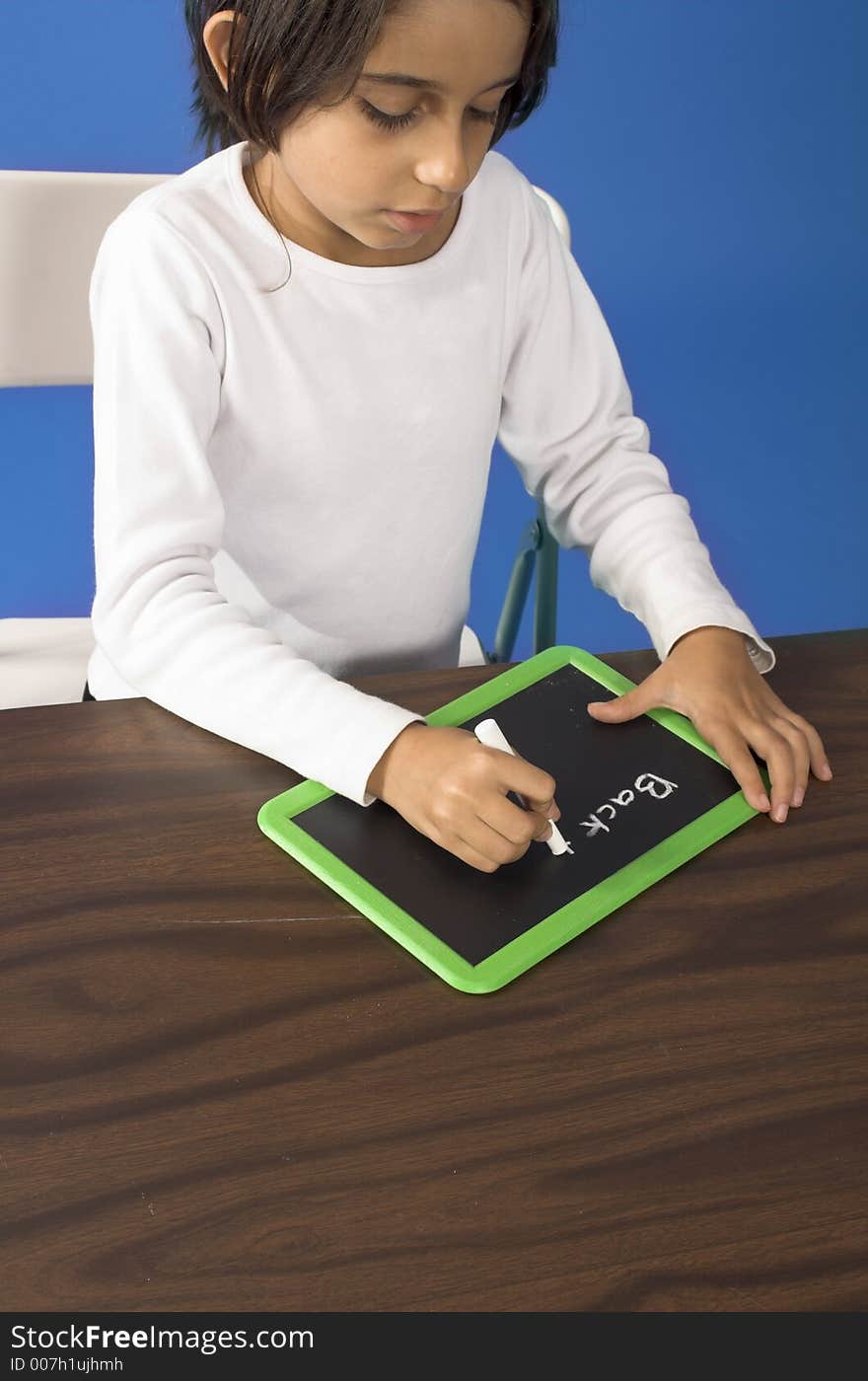 Little girl writing on board over blue background. Little girl writing on board over blue background