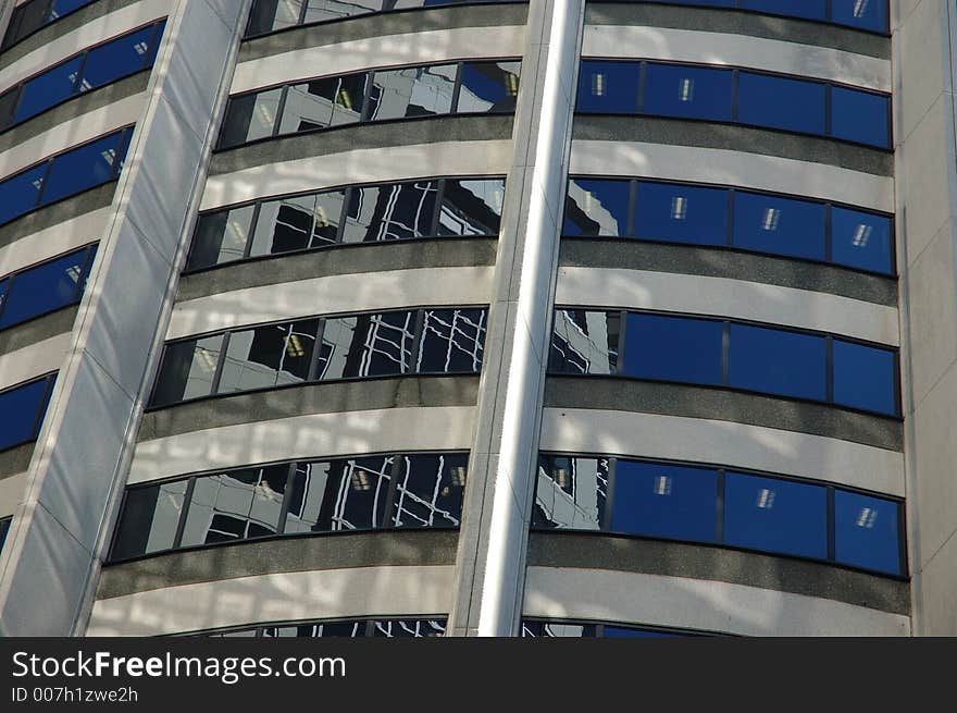 Reflection of apartment next door on the glass window of a curvy building