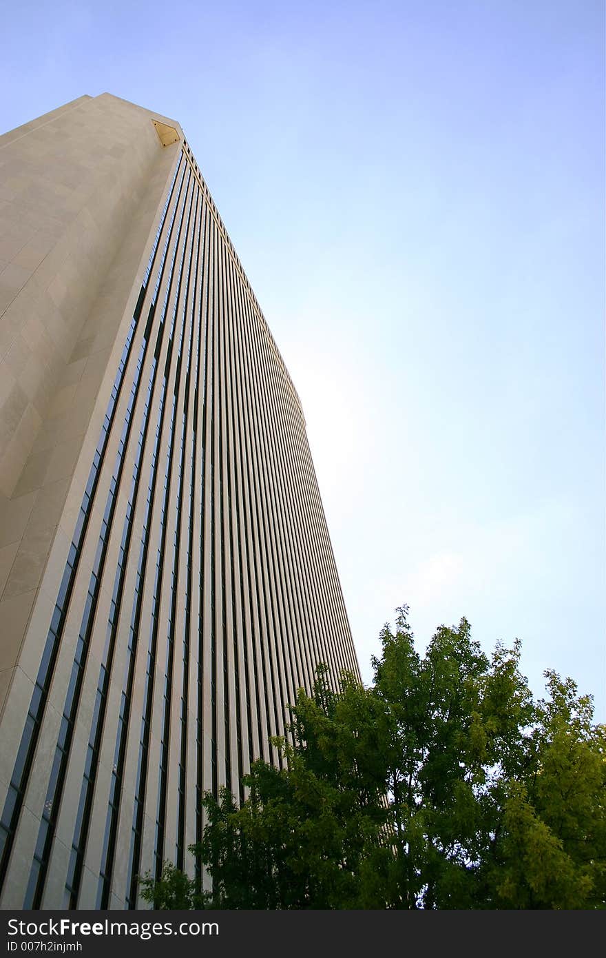 Looking up at an office building against a clear bright sky. Looking up at an office building against a clear bright sky.