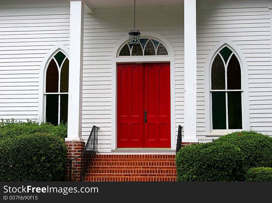 Red door on white church