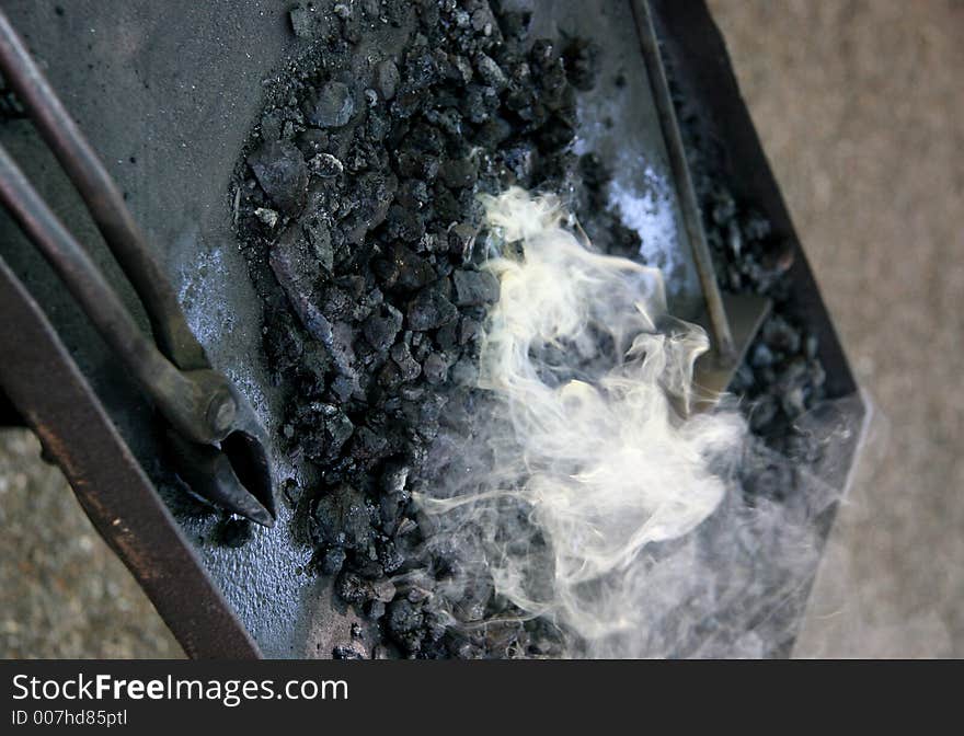 The tools of a medieval blacksmith next to hot embers. The tools of a medieval blacksmith next to hot embers.