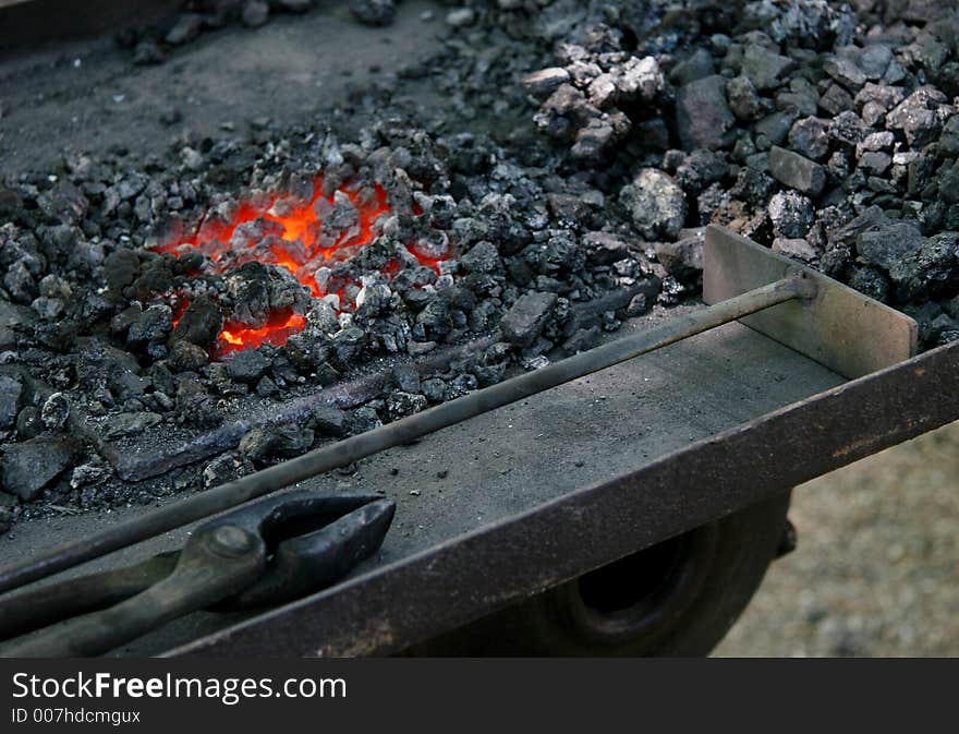 The tools of a medieval blacksmith next to hot embers. The tools of a medieval blacksmith next to hot embers.