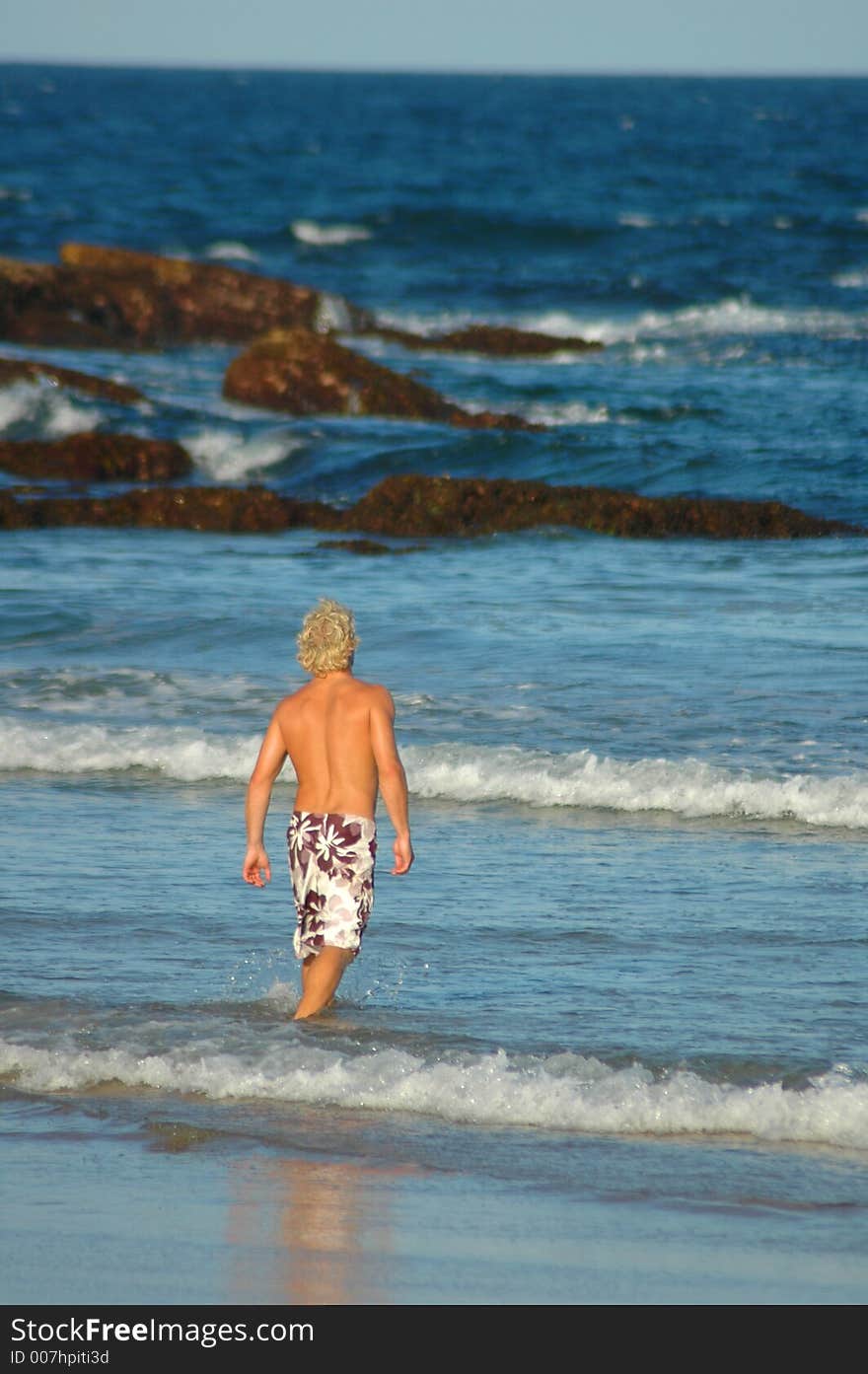 Man walking into water at beach. Man walking into water at beach