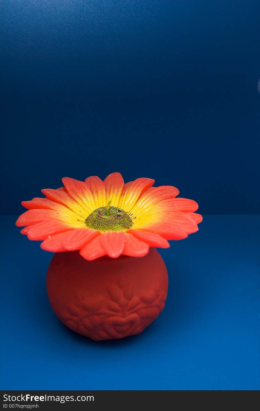 Big flower candle posed on a blue shelf. Big flower candle posed on a blue shelf