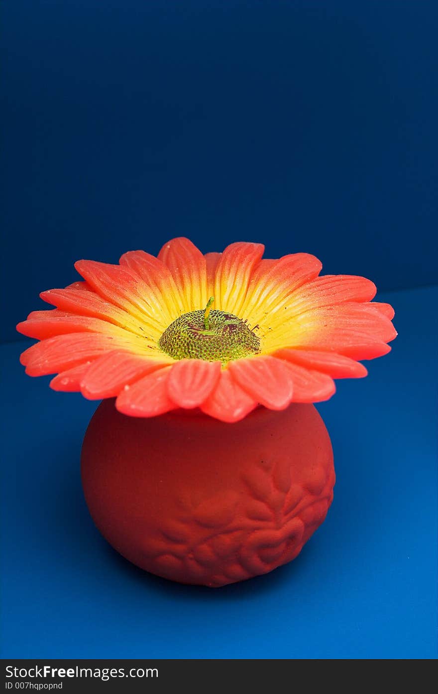 Big flower candle posed on a blue shelf. Big flower candle posed on a blue shelf