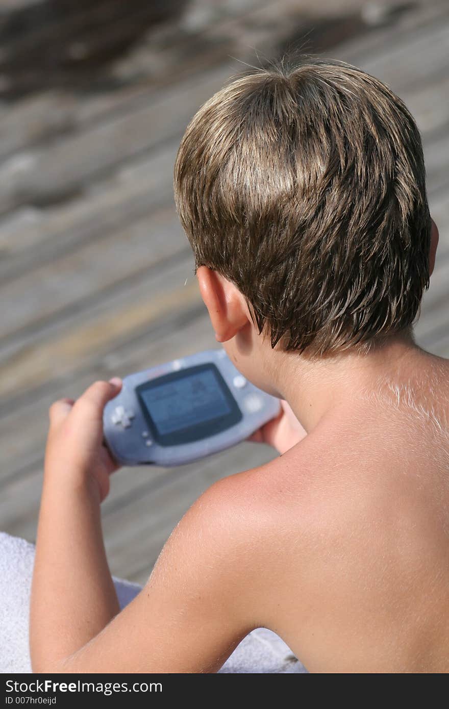 Young Boy playing video game on dock