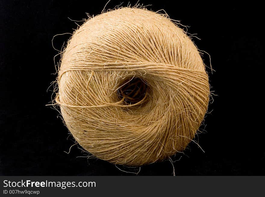 A large roll of twine on a black background. A large roll of twine on a black background.