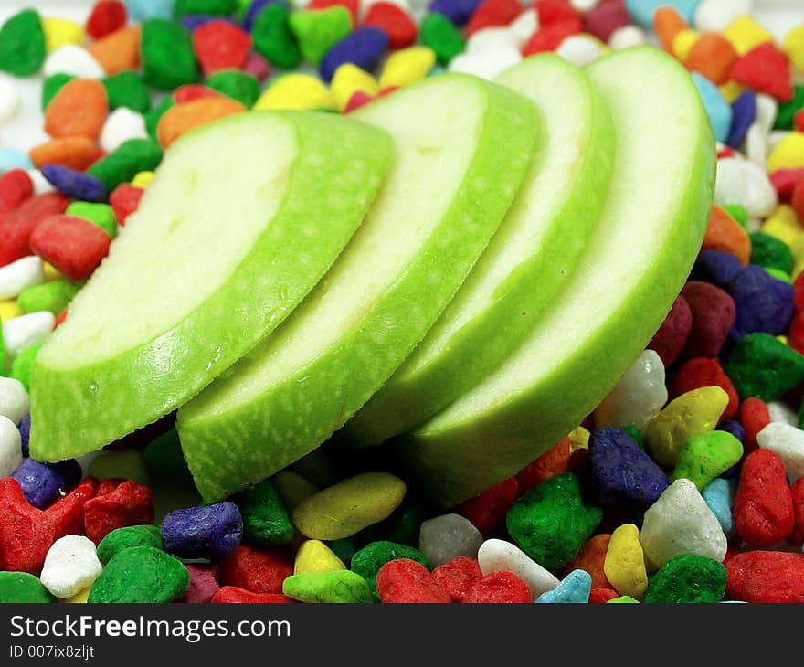 Sliced apple and funny colors stones