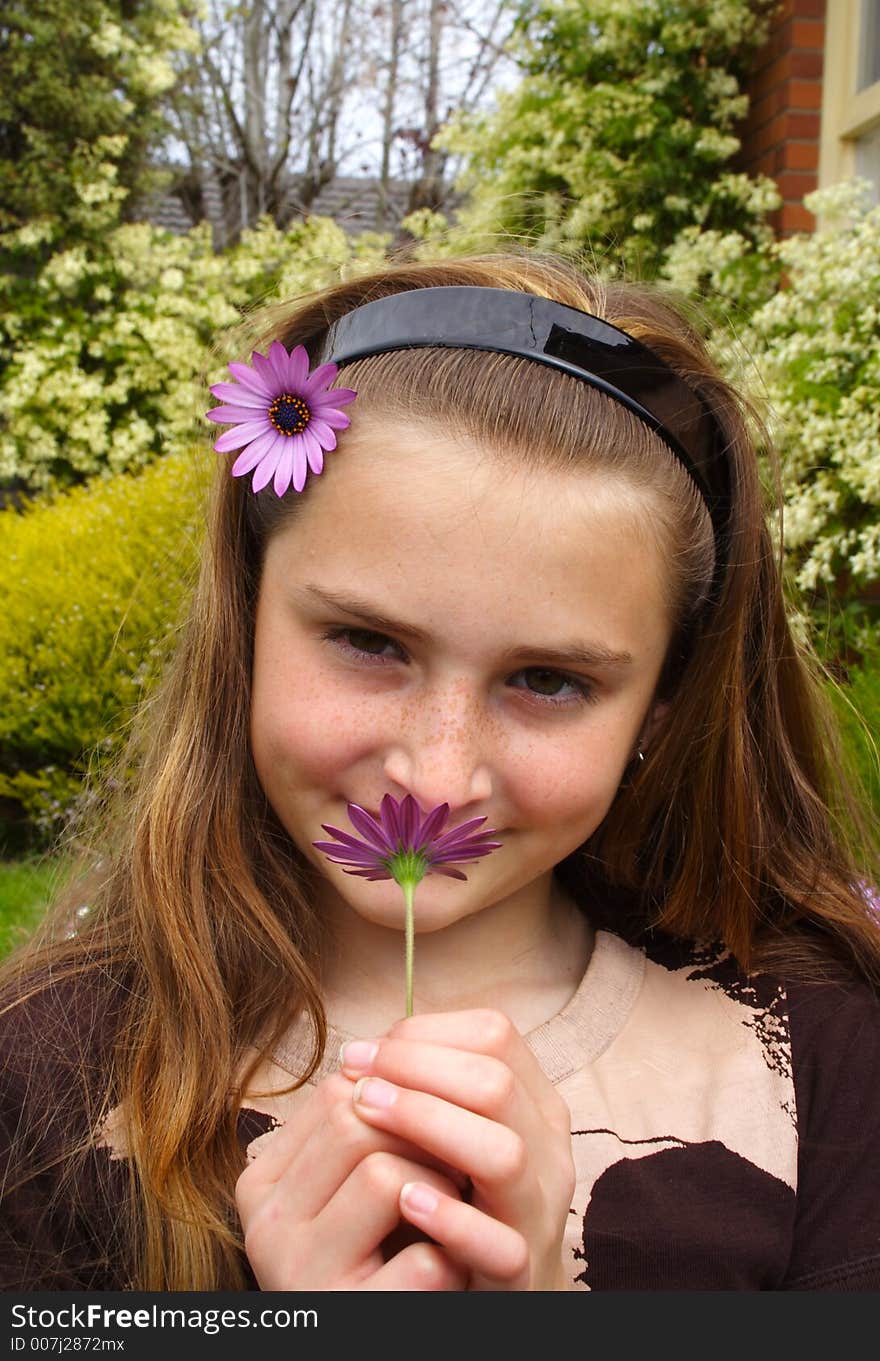 Beautiful young girl smelling flower