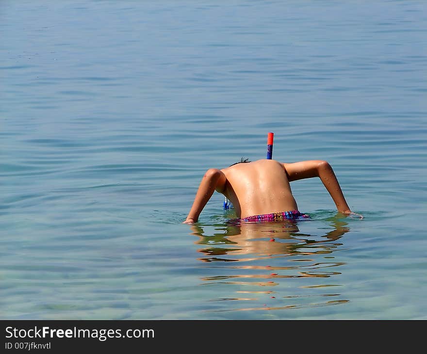 Kid in sea ready to dive and explore. Kid in sea ready to dive and explore