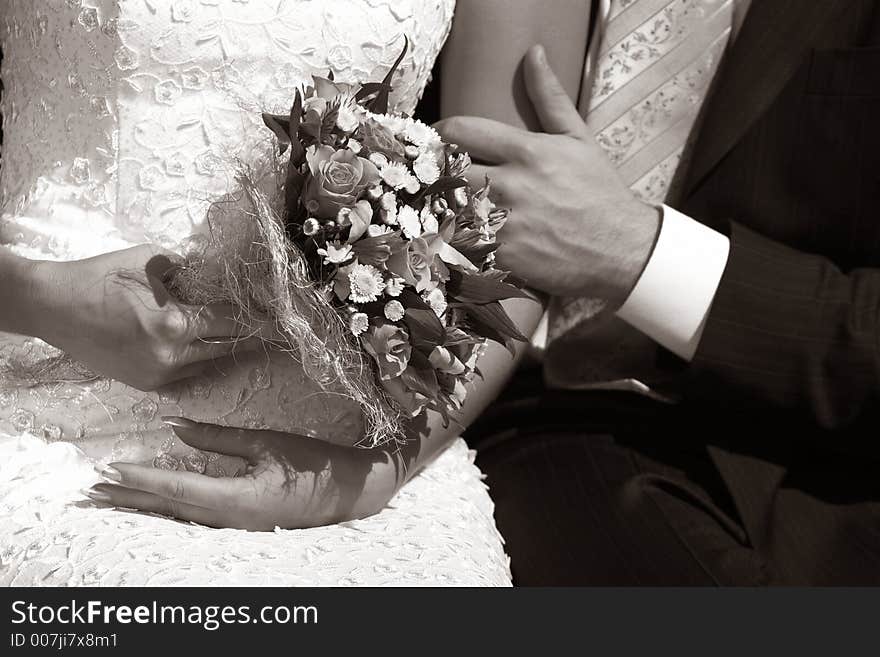 Wedding bouquet in hands of the bride. b/w+sepia