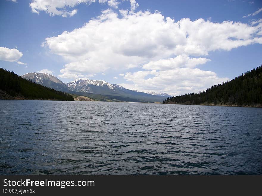 A reflective image on lake dillon higghlighted by the ten mile range and a blue sky accented by scattered clouds. A reflective image on lake dillon higghlighted by the ten mile range and a blue sky accented by scattered clouds