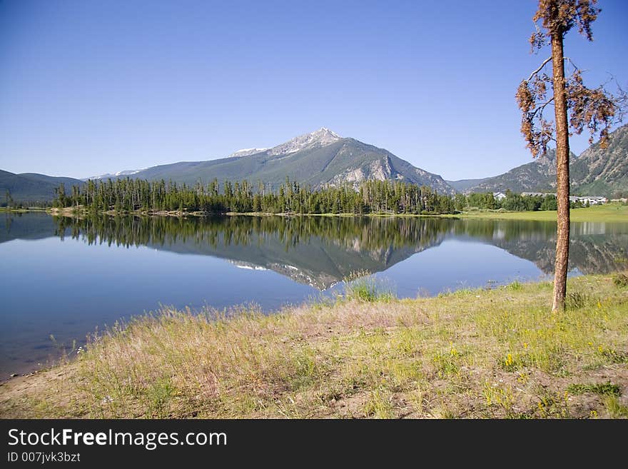 A reflective image on lake dillon higghlighted by the ten mile range and a blue sky accented by scattered clouds. A reflective image on lake dillon higghlighted by the ten mile range and a blue sky accented by scattered clouds