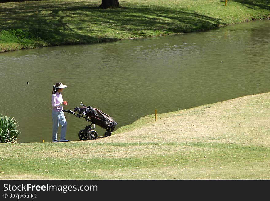 Lagy golfer looking for her ball. Lagy golfer looking for her ball