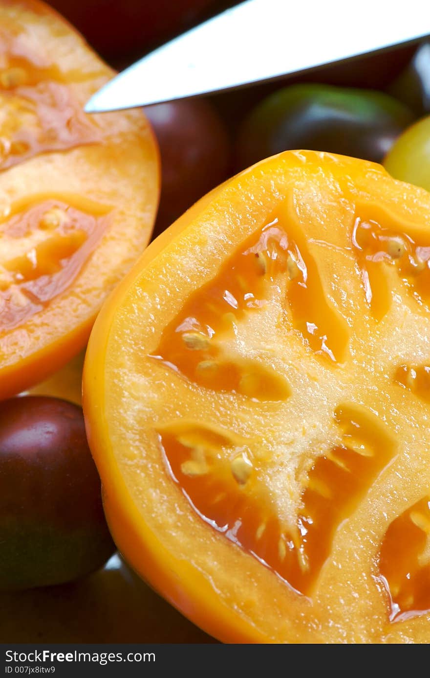 Sliced heirloom orange tomatoes with visible knife. Sliced heirloom orange tomatoes with visible knife