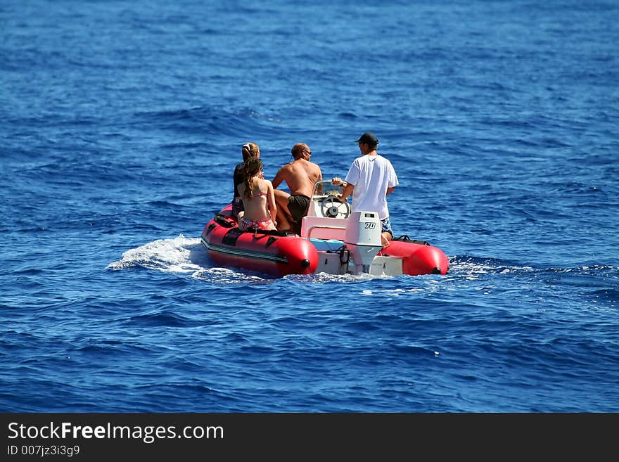 Four people on an inflatable boat, watching whales