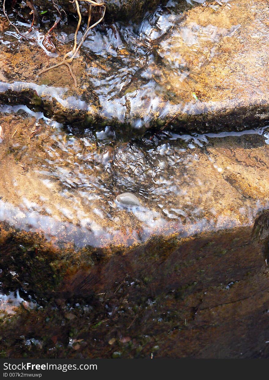 A rocky stream flowing down the side of a rock ledge. A rocky stream flowing down the side of a rock ledge.