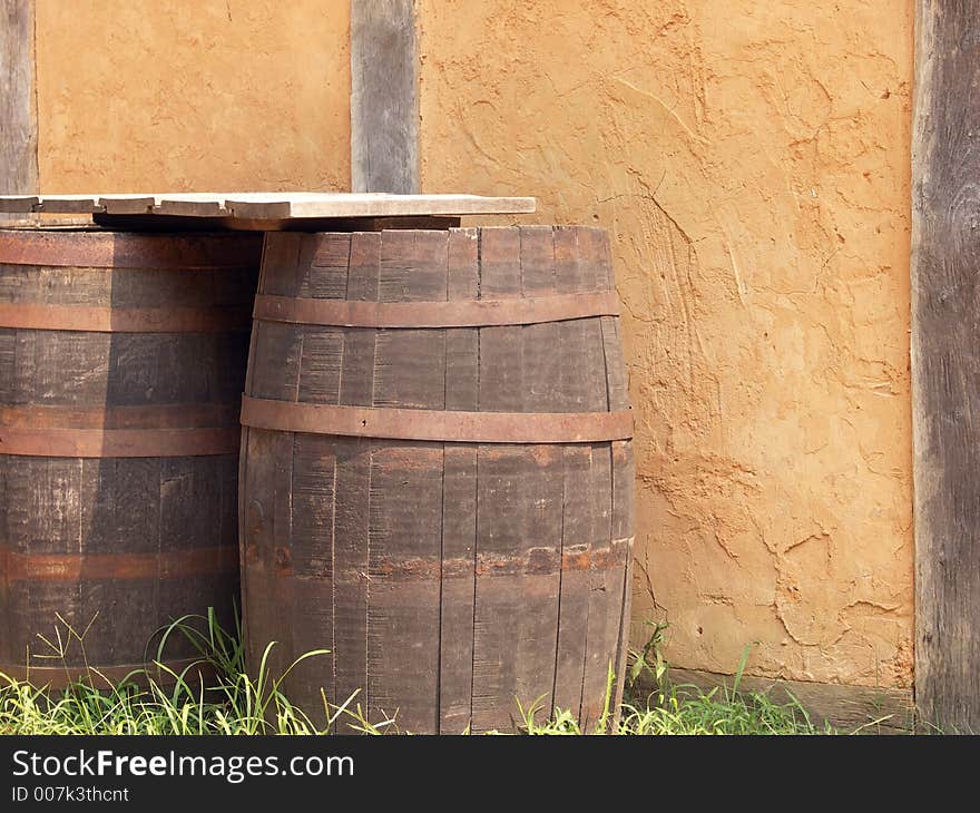 Old wooden barrels against a stucco building. Old wooden barrels against a stucco building