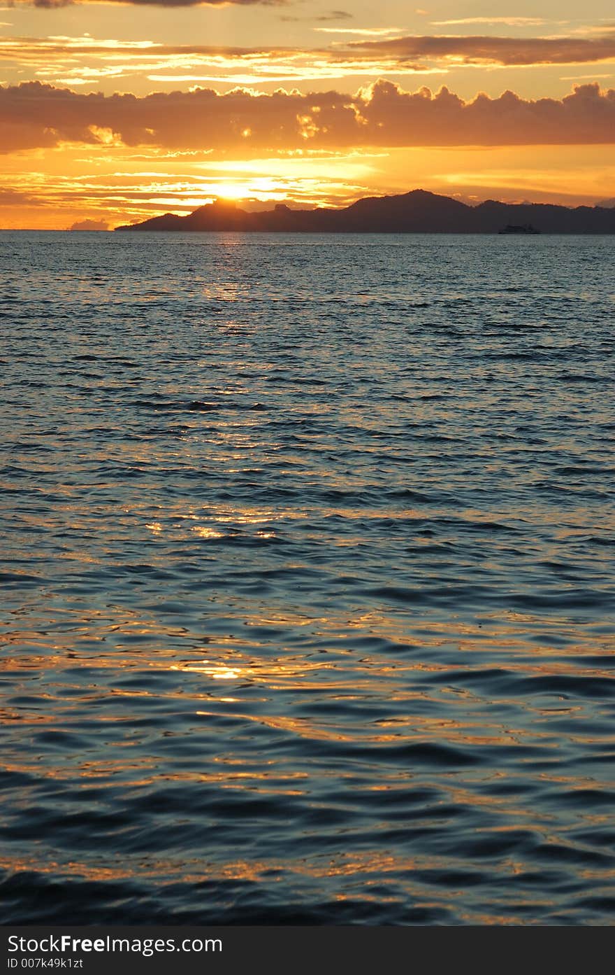 Tropical sunset silhouettes Thai island.