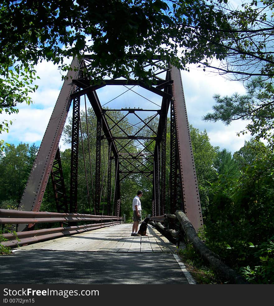 A Gentleman and his dog standing (and sitting) on a footbridge overlooking the Menominee River off Miscauno Island. . A Gentleman and his dog standing (and sitting) on a footbridge overlooking the Menominee River off Miscauno Island.