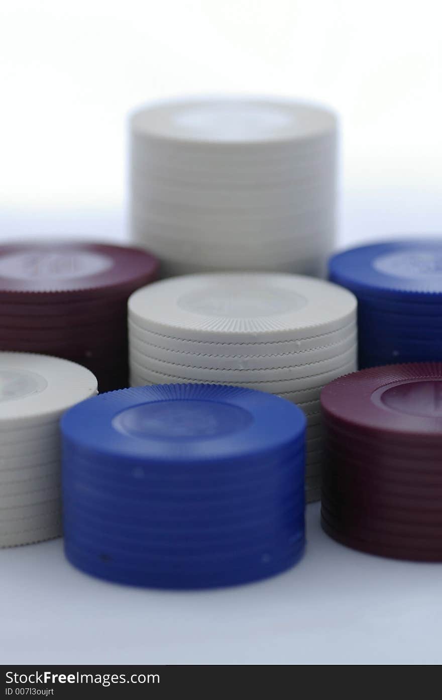 Closeup of stacked poker chips - red, white, and blue chips in seven (7) piles