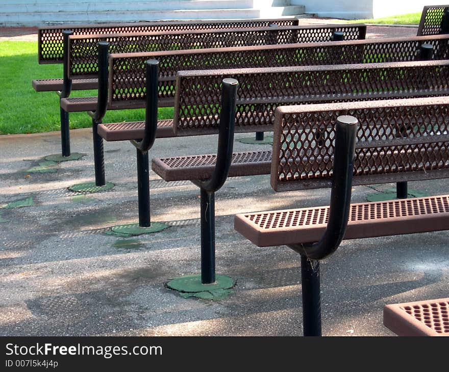 Row of metal benches in a city park. Row of metal benches in a city park.