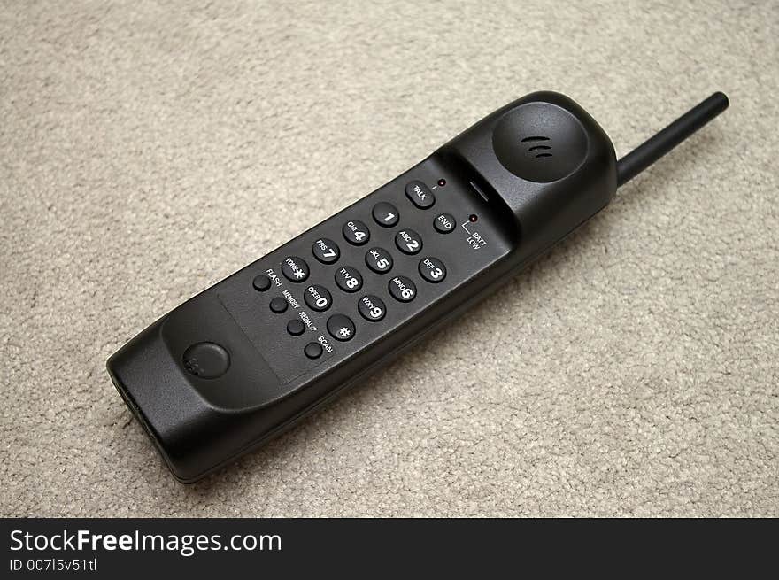 A black cordless telephone handset. A black cordless telephone handset